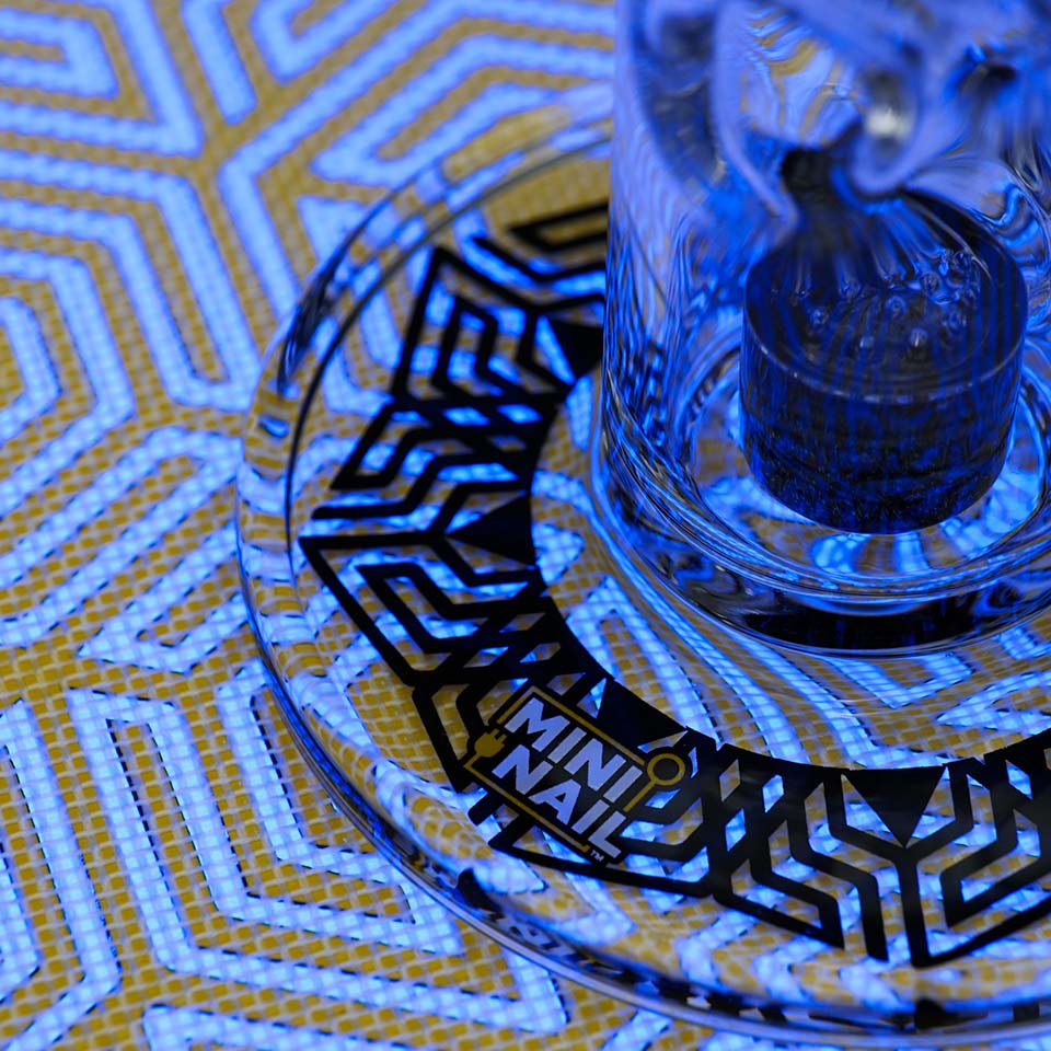 Closeup of MiniNail Multi-Color Backlit Slab Pad Shown in Blue with Glass Rig